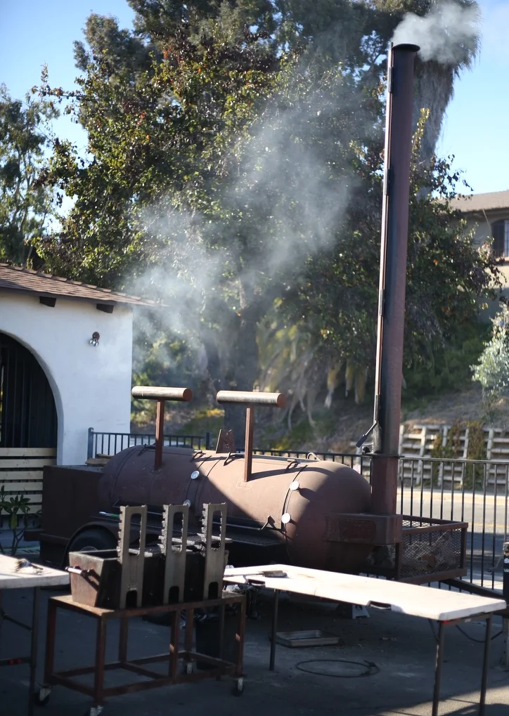 Outdoor smoker releasing smoke at a barbecue restaurant