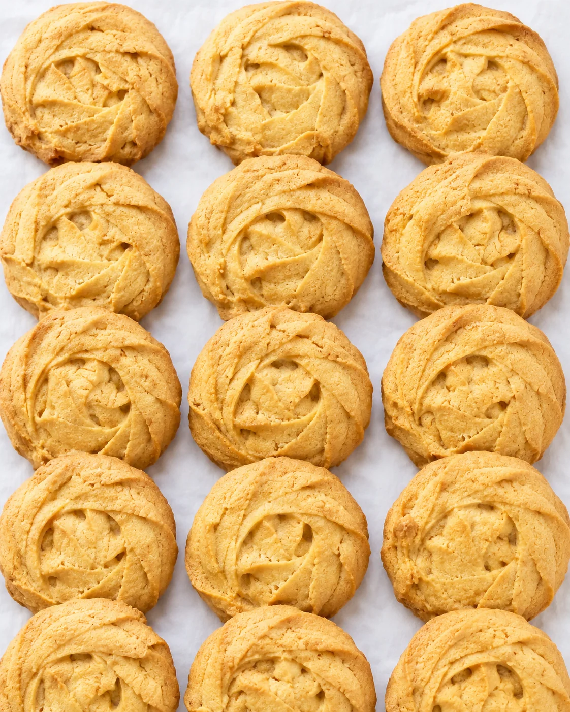 Freshly baked pumpkin cookies arranged on parchment paper