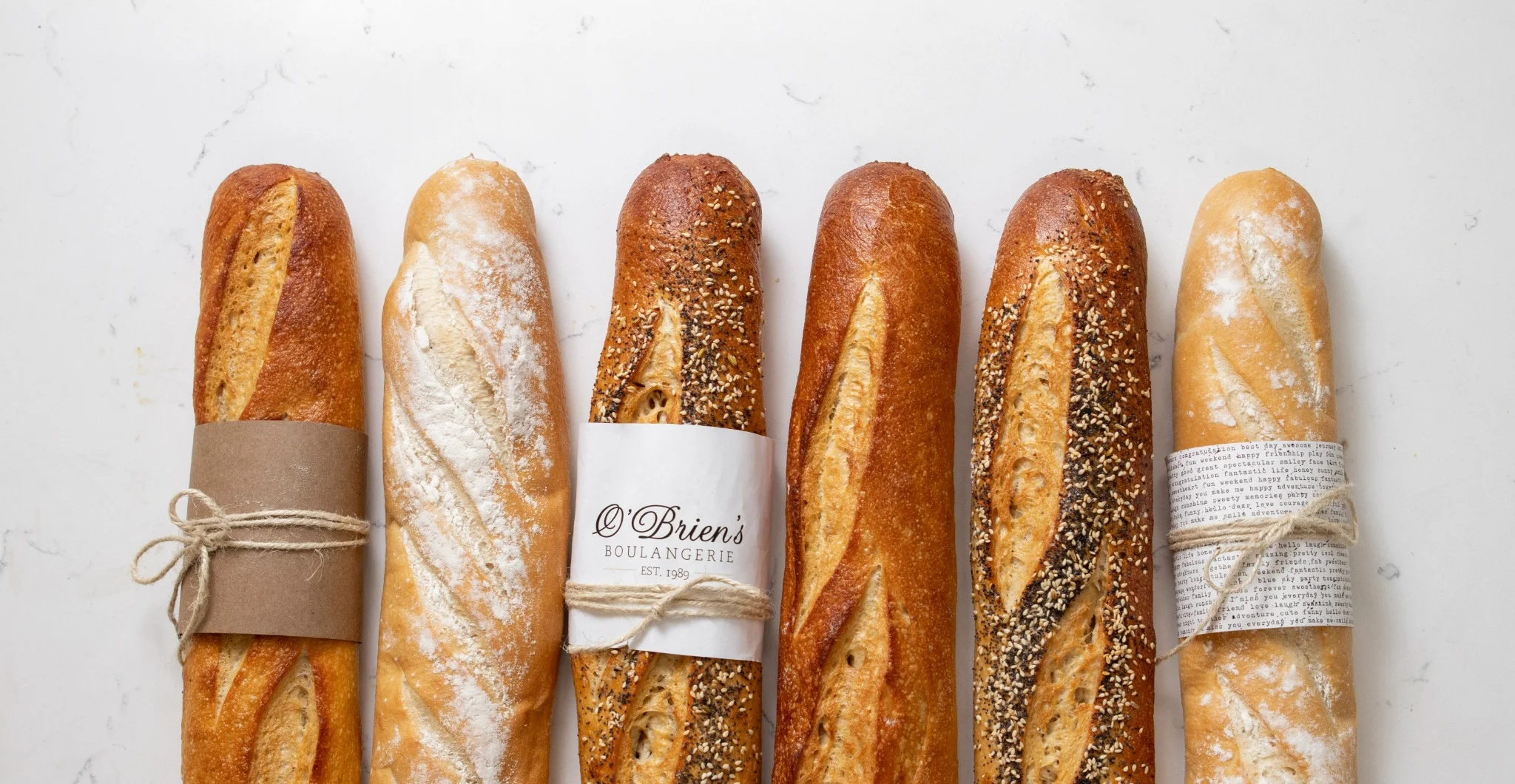 A variety of fresh baguettes displayed on a wooden board.