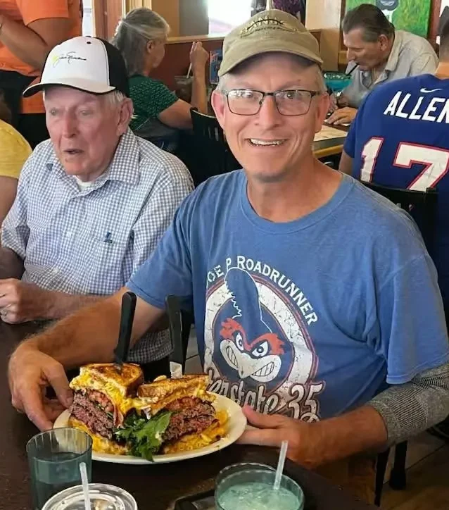 Giant cheeseburger served in a lively restaurant setting