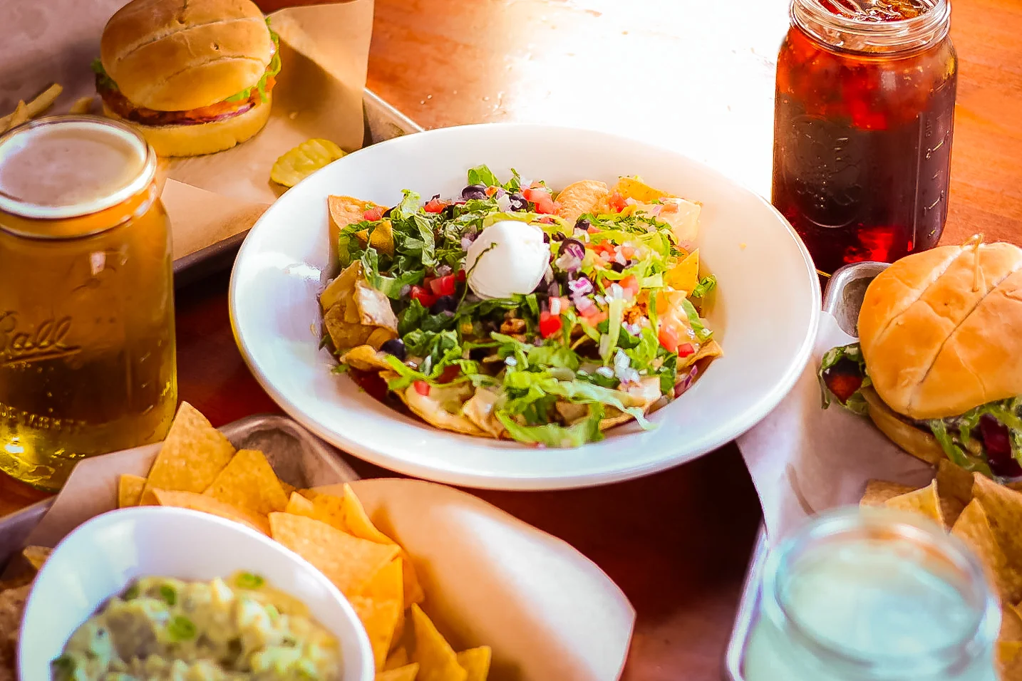 Colorful Mexican nachos topped with fresh greens and sour cream