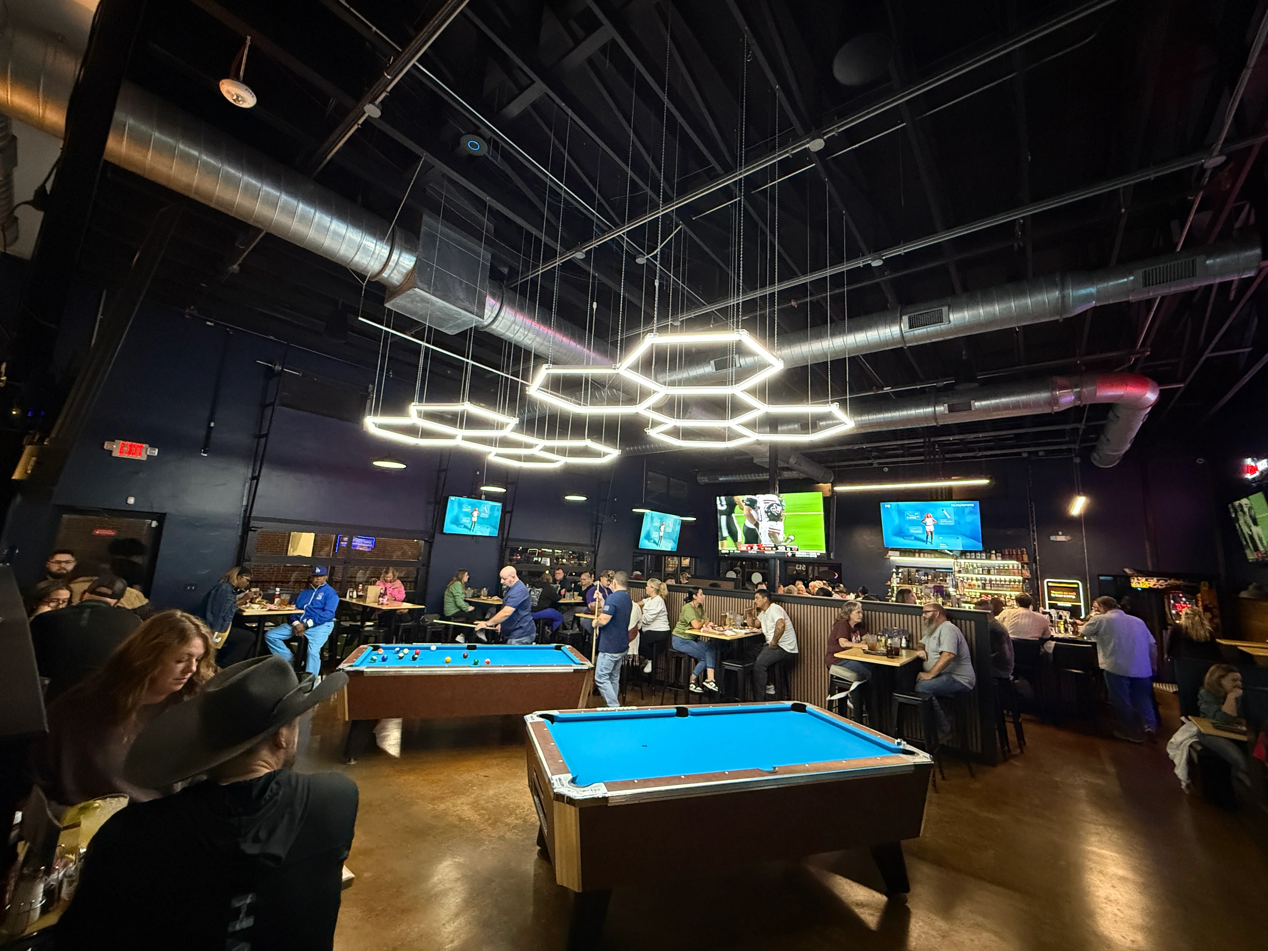 Vibrant bar and pool hall with modern lighting and lively atmosphere