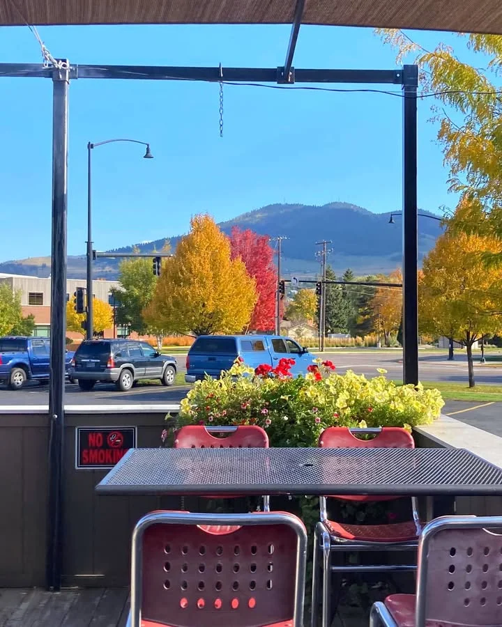 Outdoor dining area with autumn foliage and mountain view