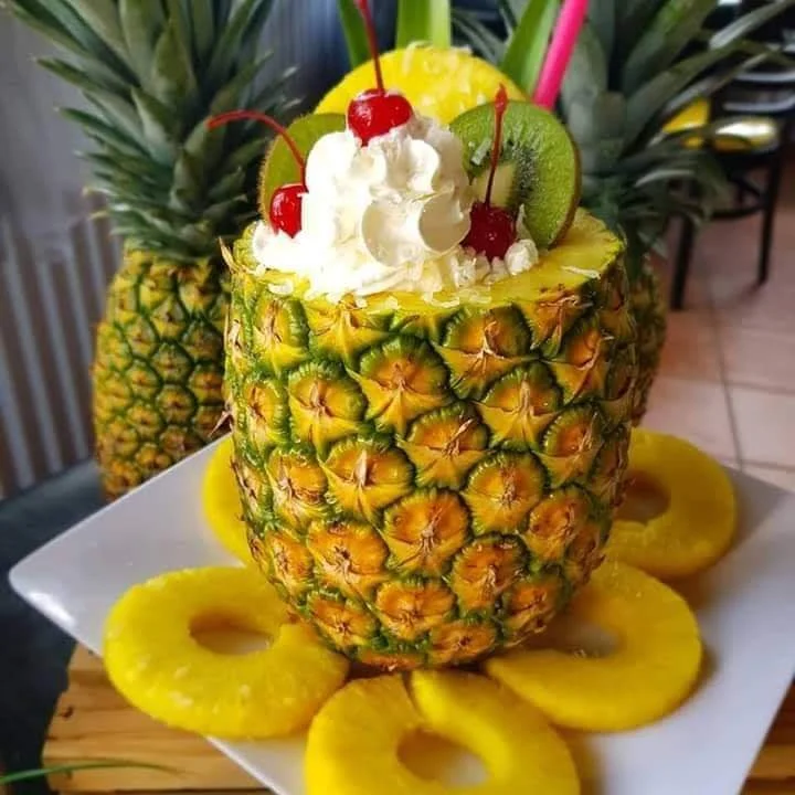 Tropical pineapple dessert with whipped cream and cherries