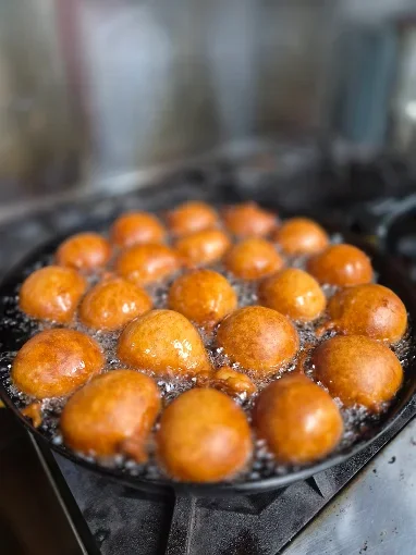 Fried Indian gulab jamun balls in hot oil