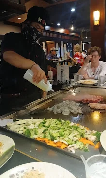 Japanese teppanyaki chef preparing fresh ingredients at the grill