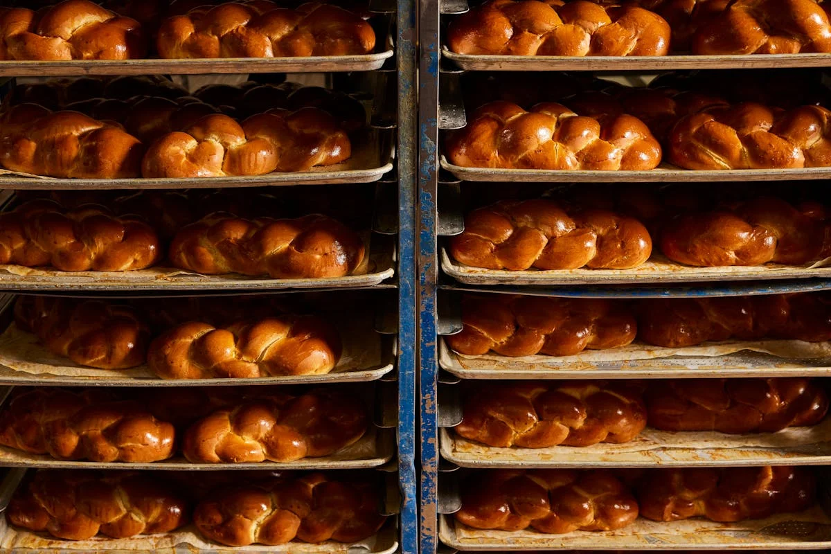 Freshly baked challah bread loaves on trays