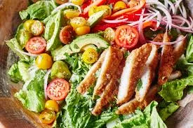 A vibrant salad topped with crispy chicken wings and fresh vegetables.