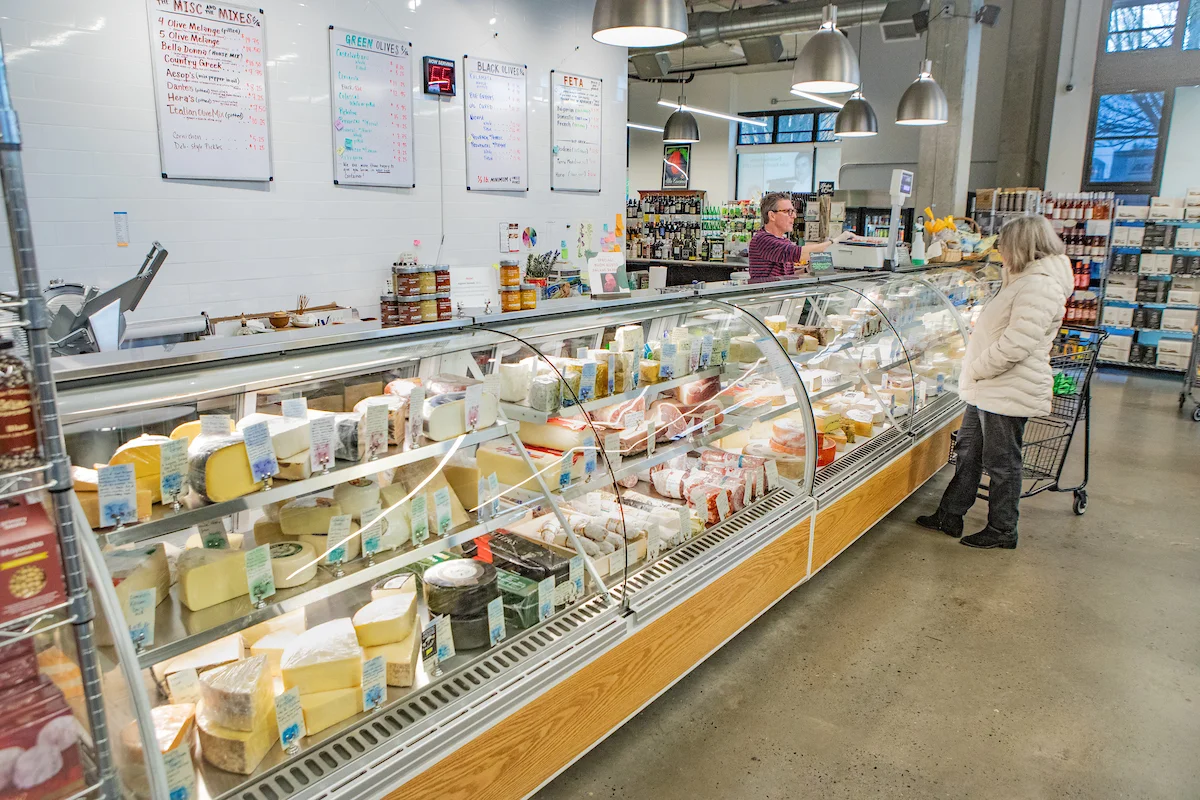 Cheese display in a gourmet market with various artisanal cheeses