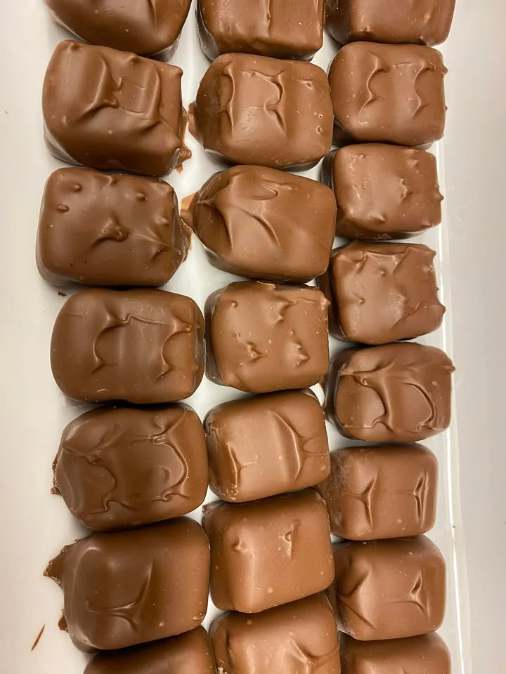 A close-up view of multiple pieces of chocolate confections arranged neatly.