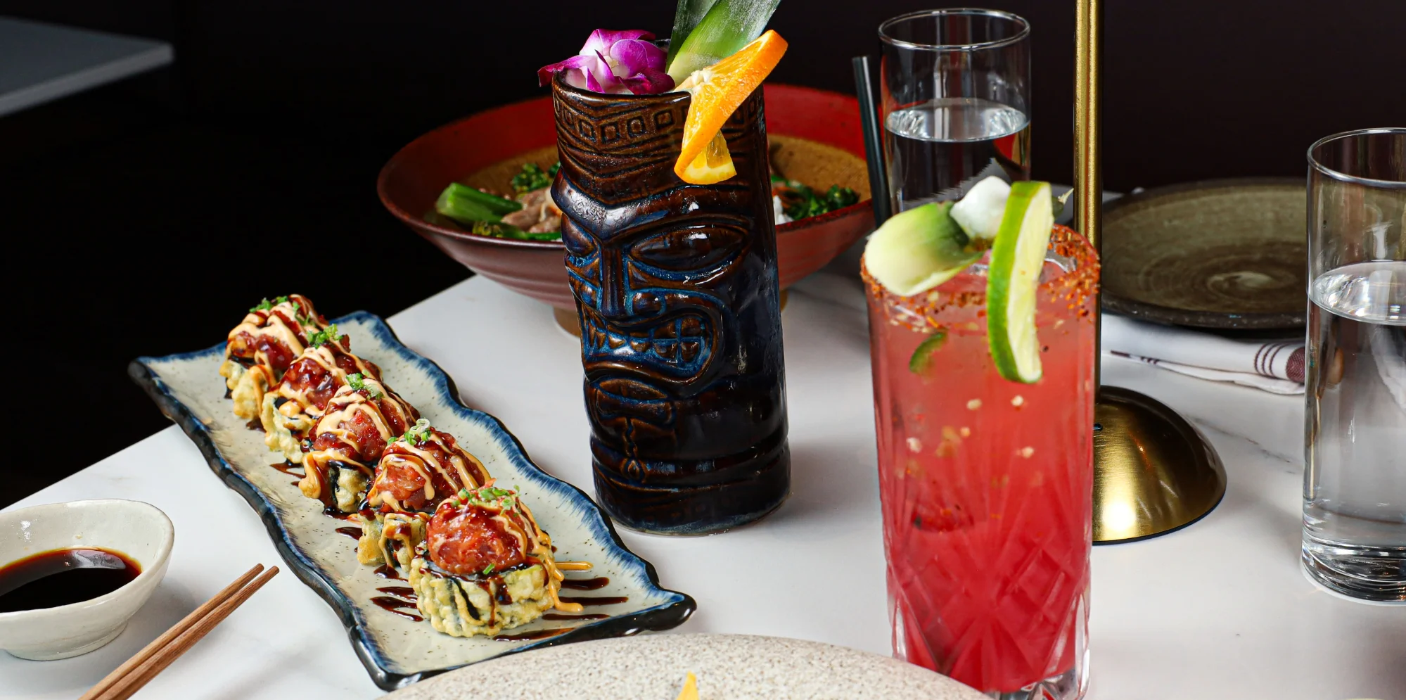 Colorful sushi platter with cocktails in a vibrant restaurant setting