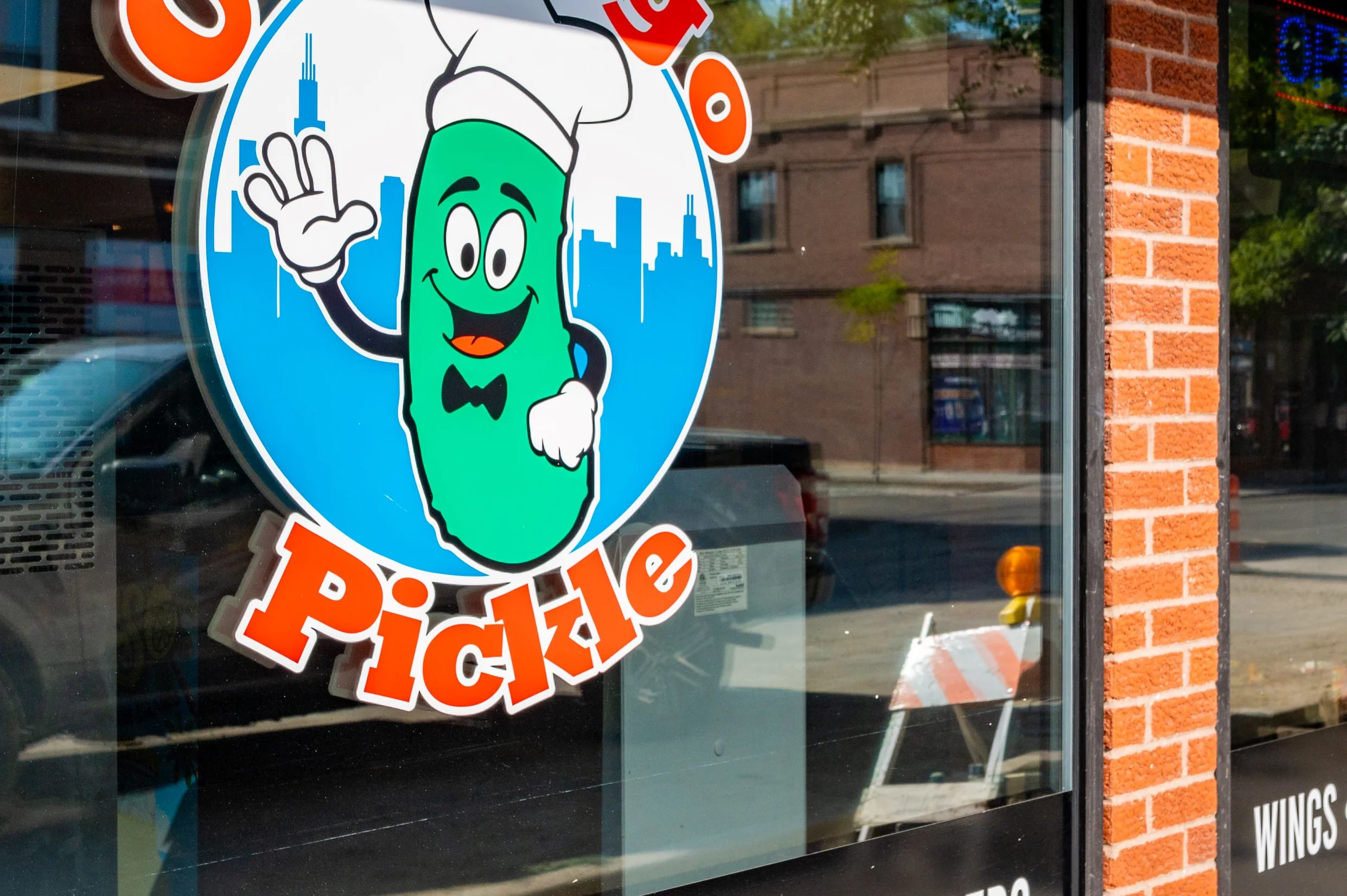 Exterior view of Chicago Pickle restaurant with colorful logo and menu highlights.