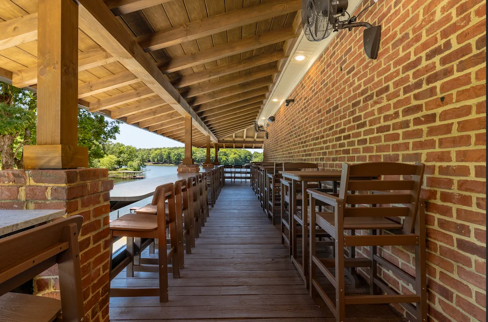 Outdoor seating area with a view of the water and wooden structure.