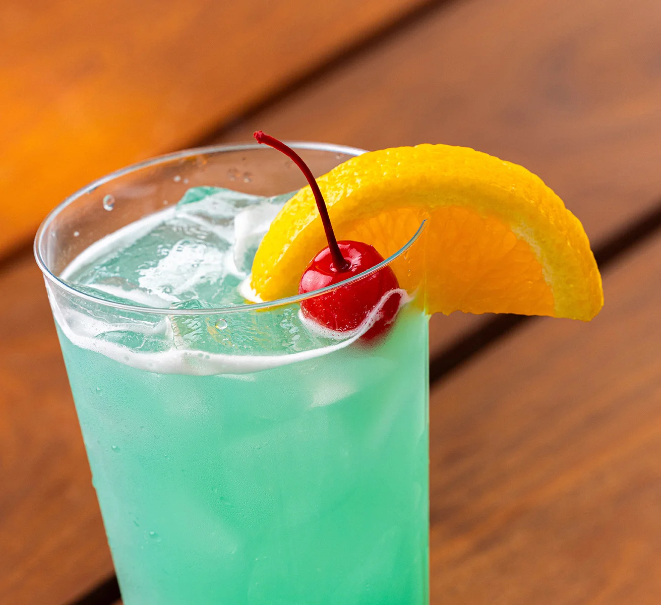 Blue Tsunami drink with a cherry and orange garnish