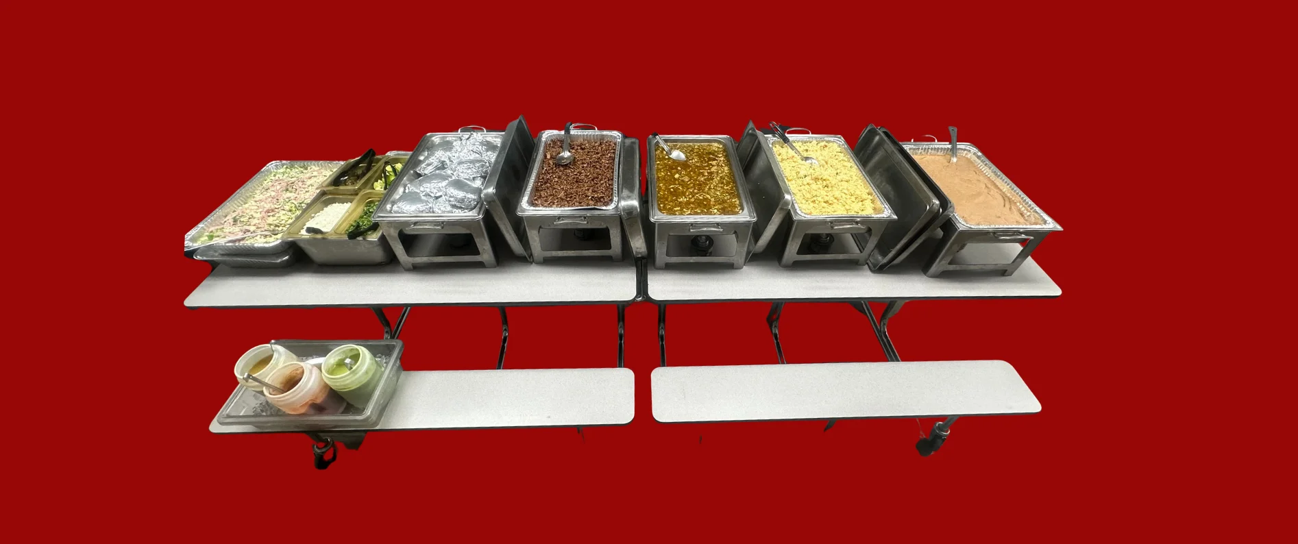 Buffet setup with various food trays on tables.