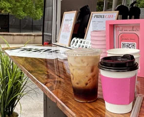 Coffee cups at a vibrant café counter with greenery
