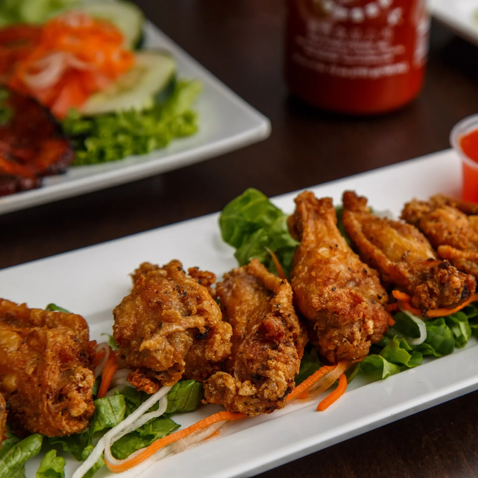 Crispy Vietnamese fried chicken wings on a bed of greens