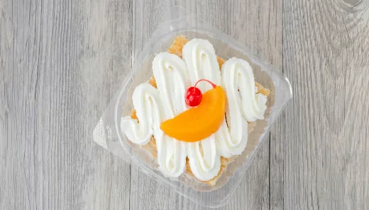 Delicious slice of cake topped with cream and fruit garnish