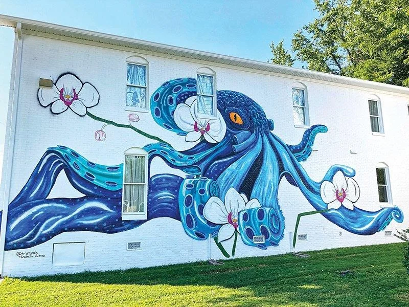 Colorful octopus mural with orchids on a white wall