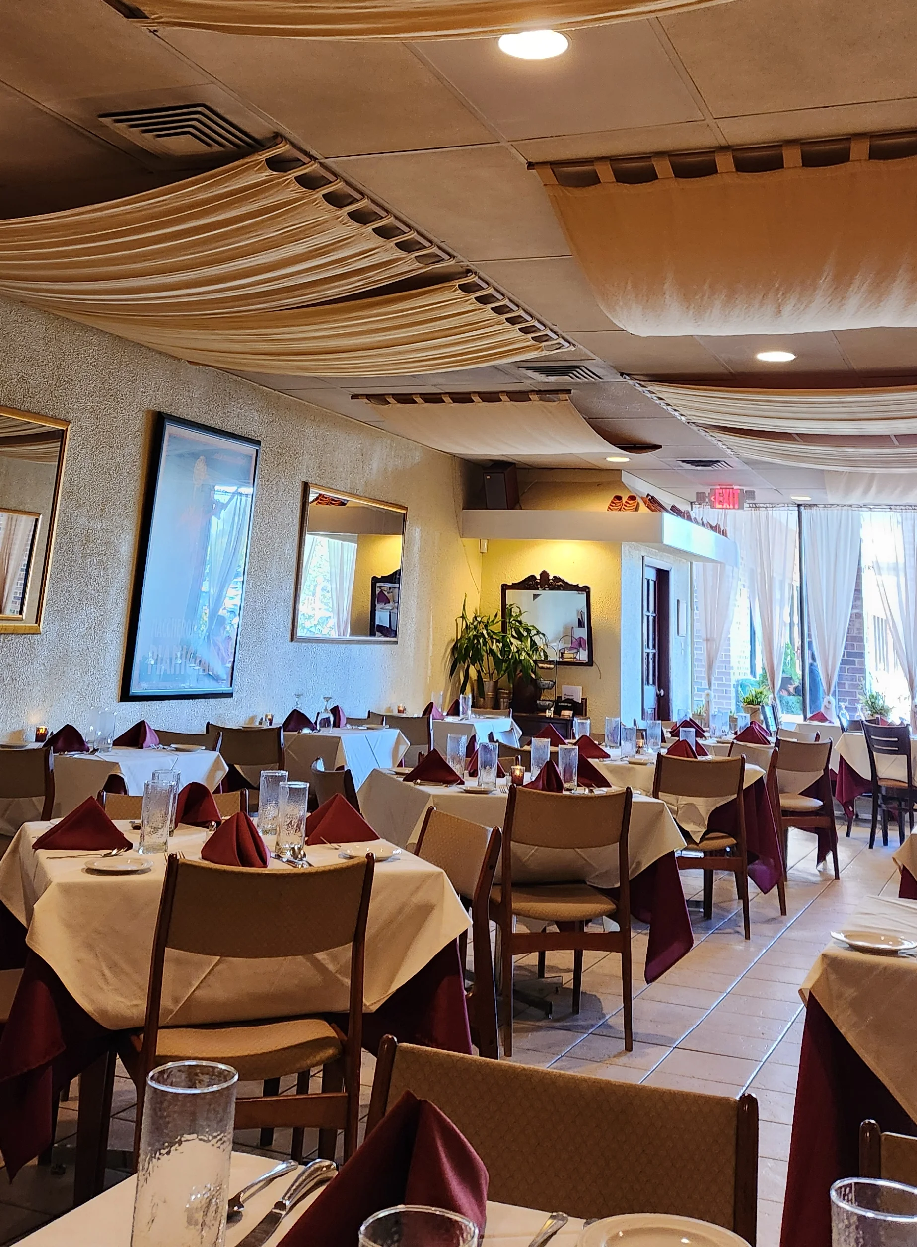 Cozy restaurant interior with draped fabric ceiling and elegant table settings