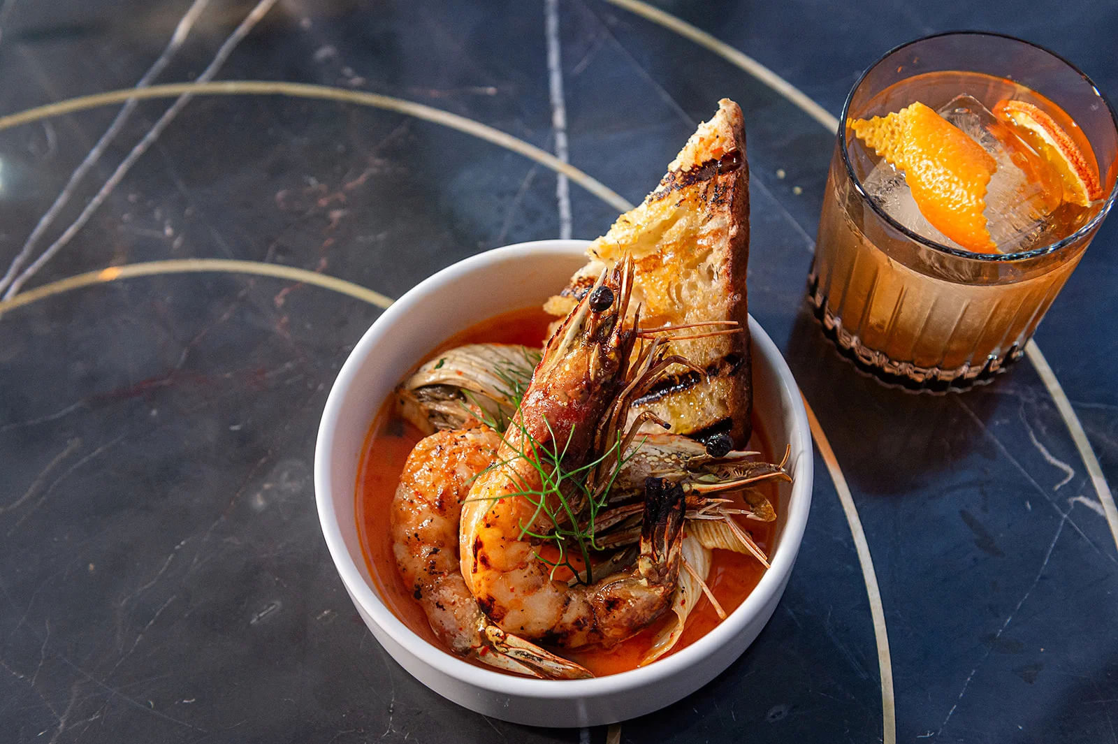 Grilled shrimp in spicy broth with toasted bread