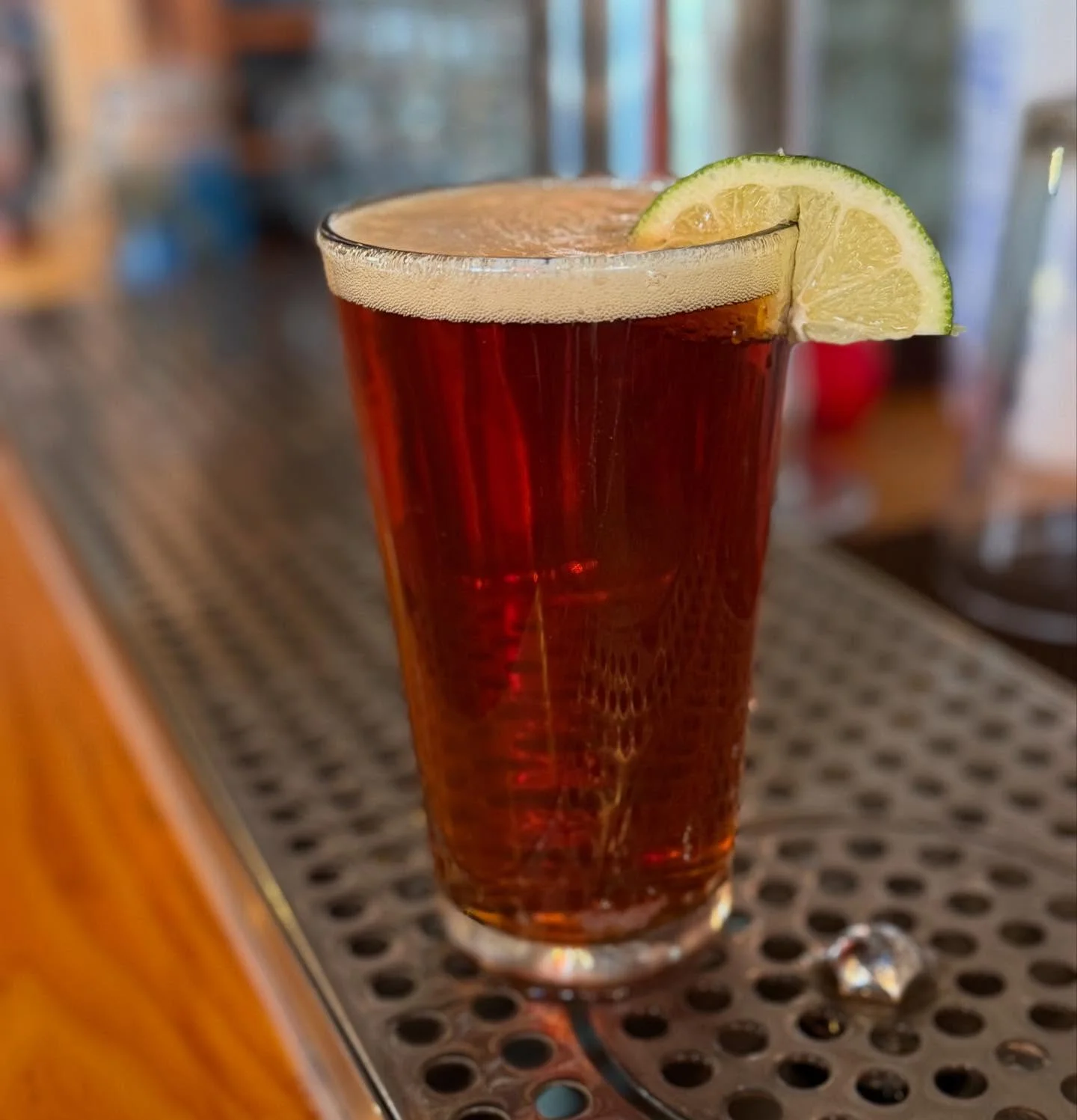 Refreshing craft beer with lime garnish on a bar counter