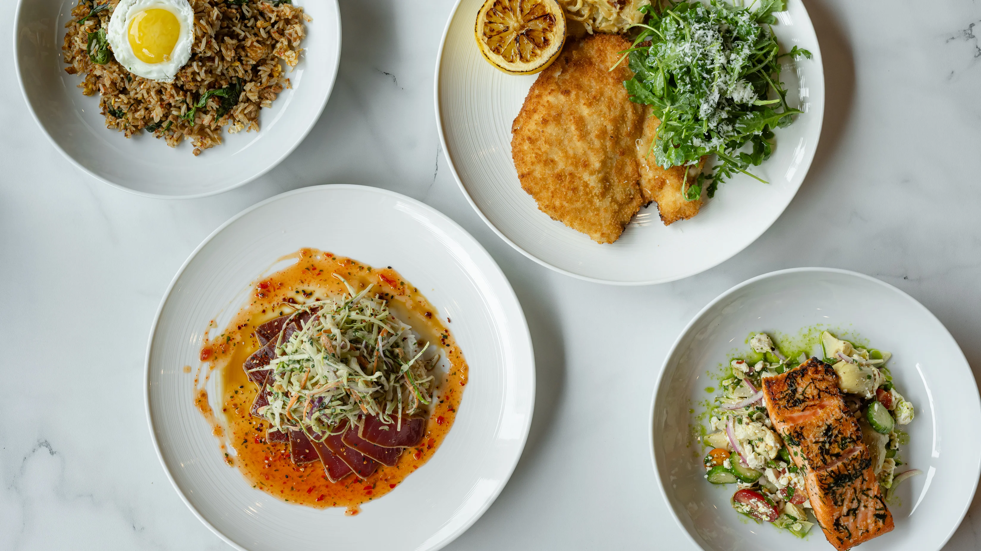 Assorted dishes including Korean bibimbap and grilled salmon salad