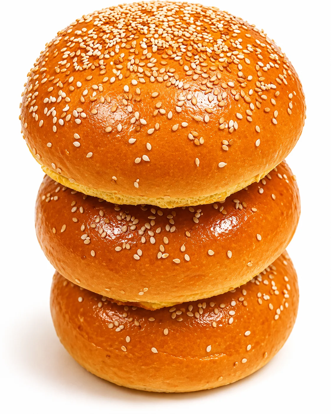 Three sesame seed burger buns stacked on top of each other.