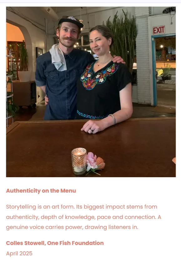 Two people posing together in a restaurant with a candle on the table.