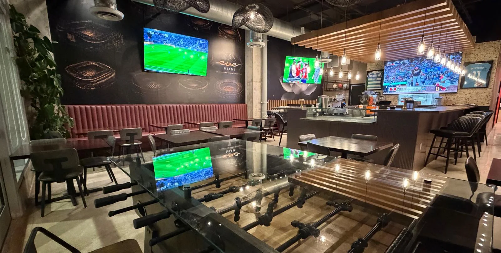 Modern restaurant interior with sports screens and foosball table