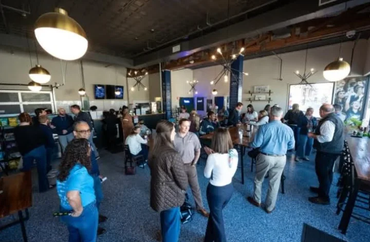 Crowd gathered at a restaurant's grand opening event.