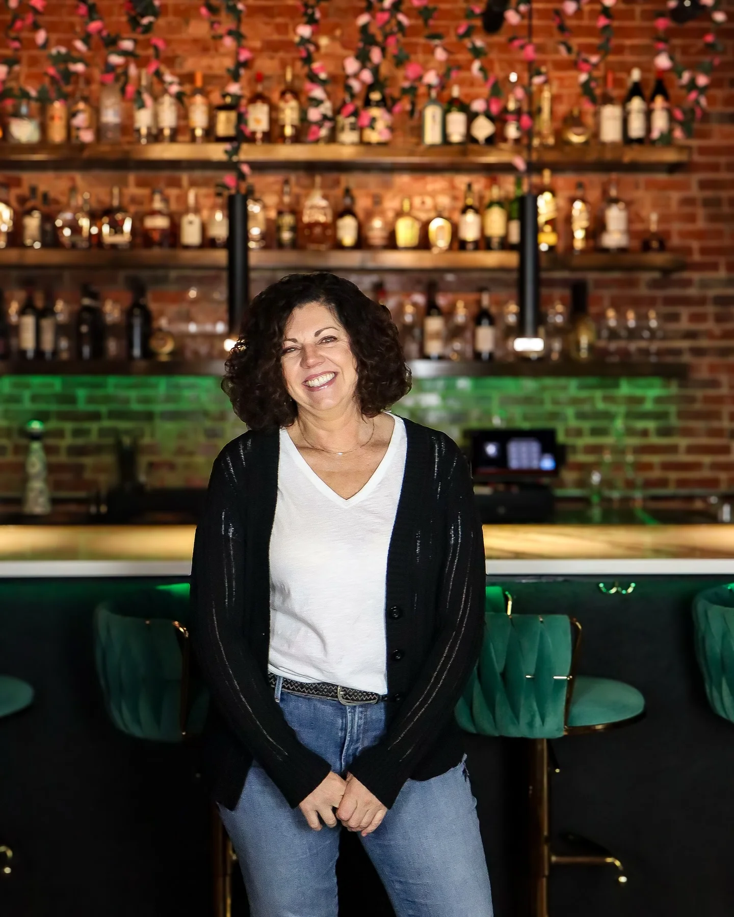 Bartender smiling in a stylish bar with a brick backdrop