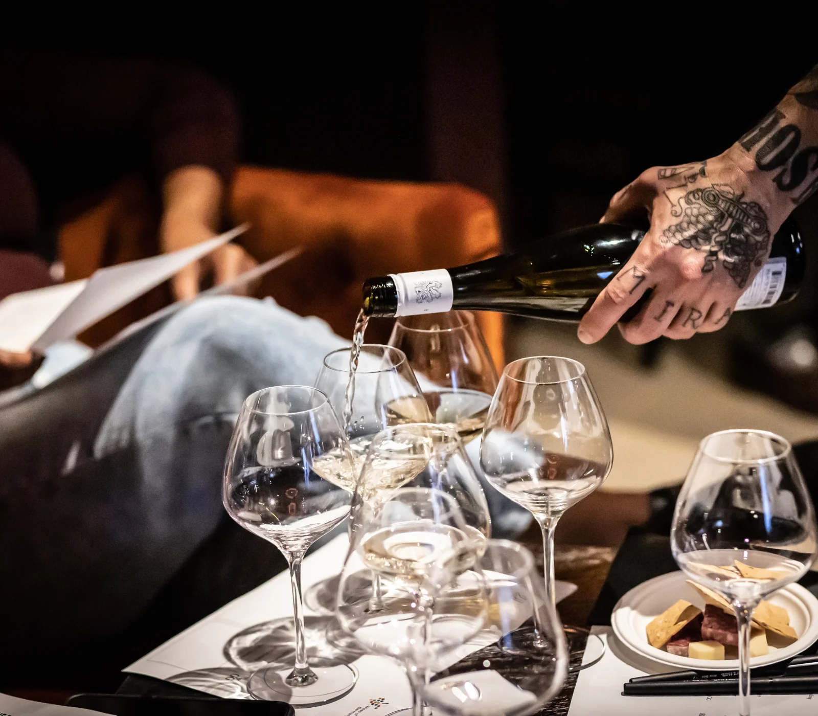 Wine being poured into glasses at a cozy dining setting
