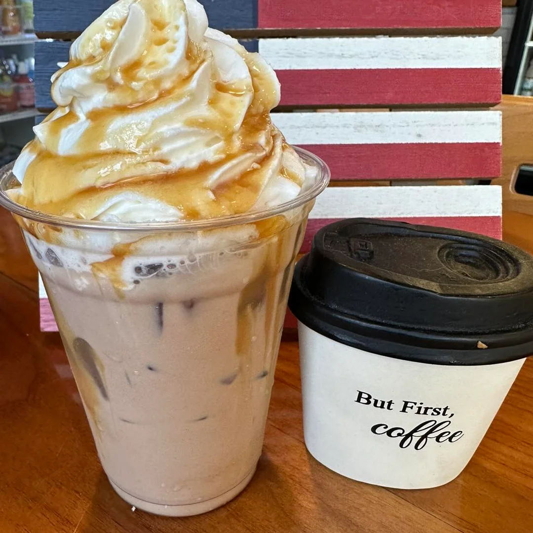 A beautifully crafted latte with intricate foam art in a white cup.