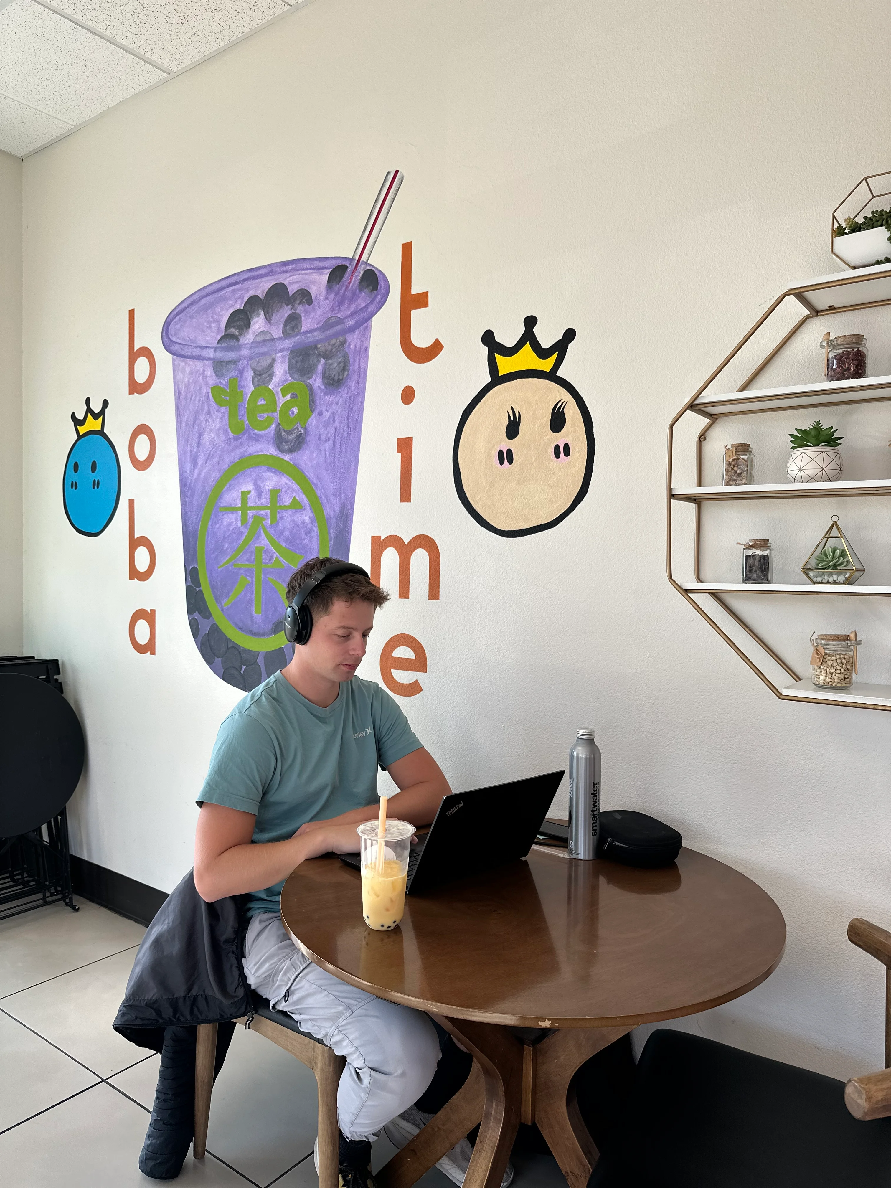 Cozy boba tea shop interior with a student working
