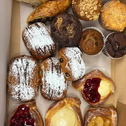 Assorted pastries and muffins in a bakery box