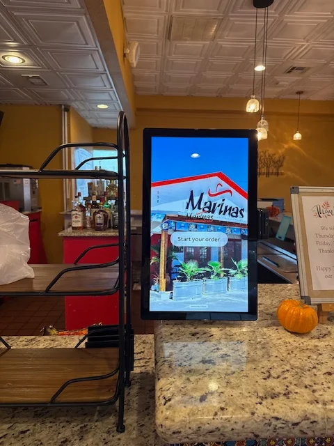 Digital ordering kiosk at a vibrant restaurant entrance