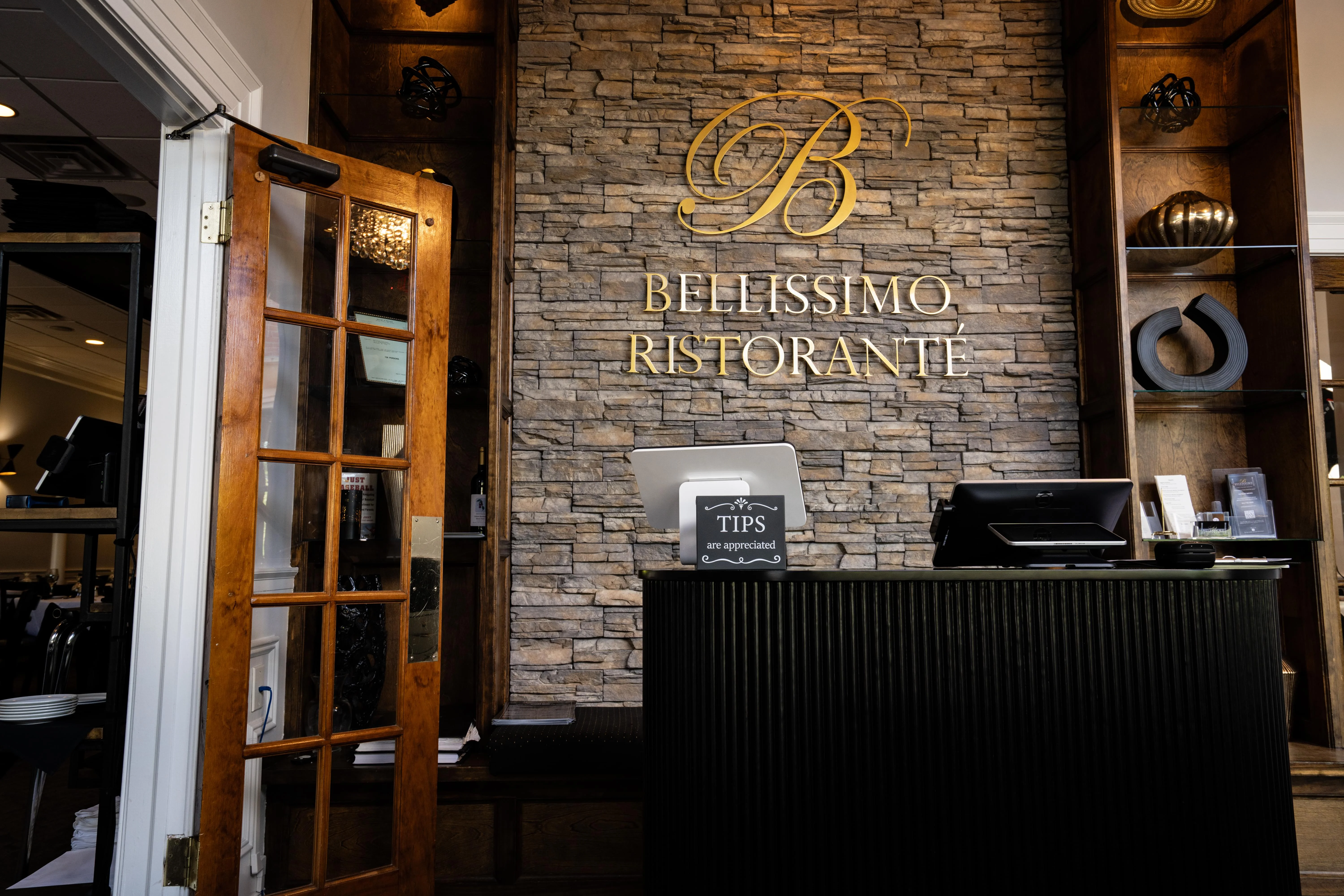 Elegant restaurant reception area with stone wall and wooden door