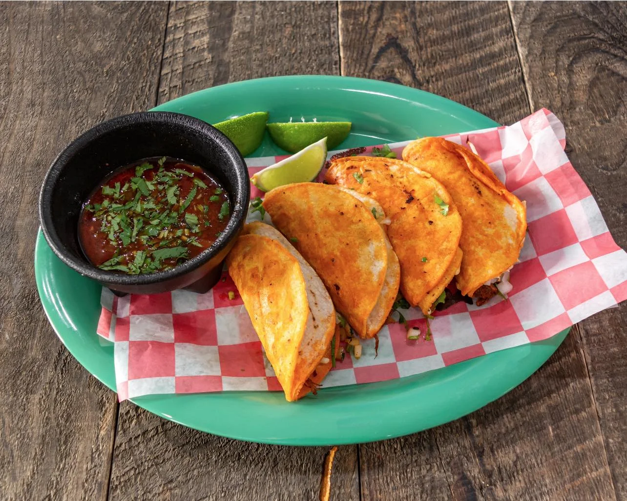 Crispy tacos served with salsa and lime wedges