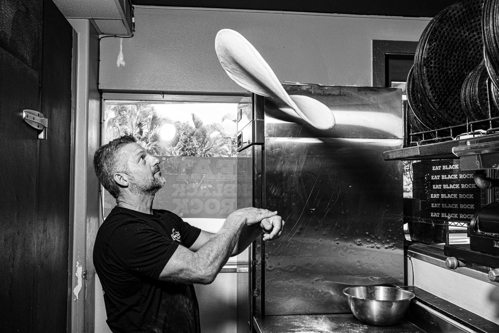Chef tossing pizza dough in a restaurant kitchen