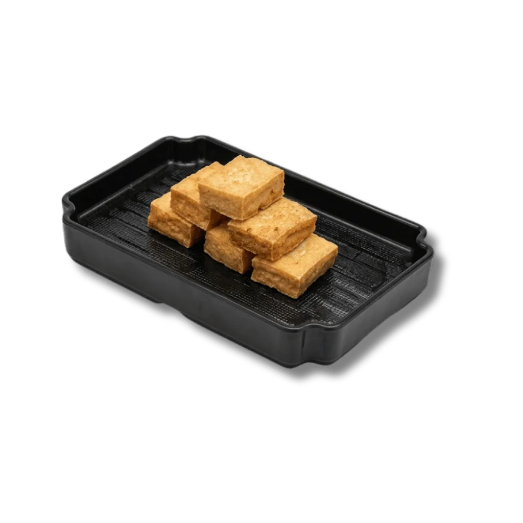A black tray with stacked pieces of golden-brown tofu.