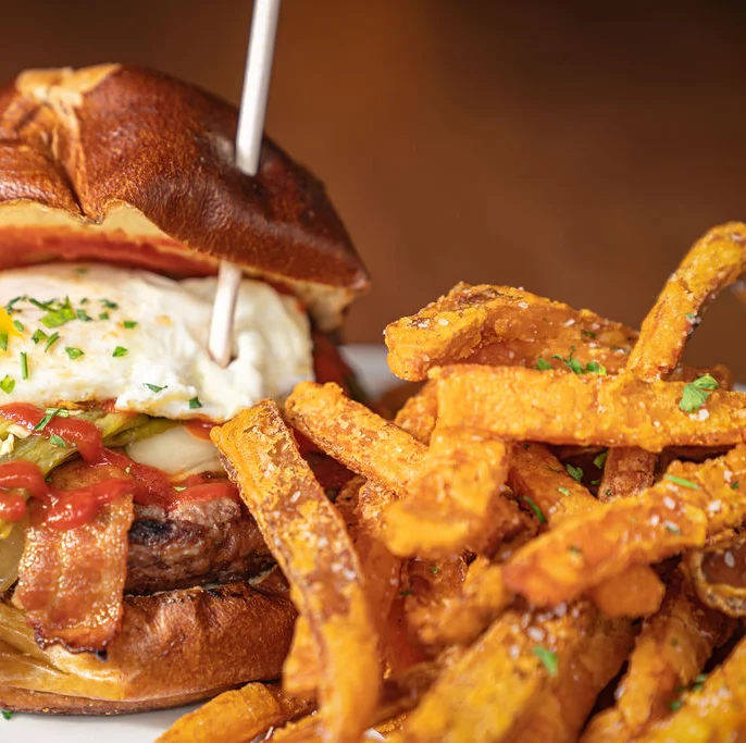 Gourmet burger with fried egg and sweet potato fries
