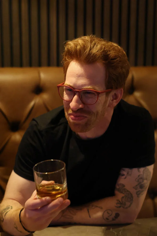 Man enjoying a whiskey in a cozy restaurant setting