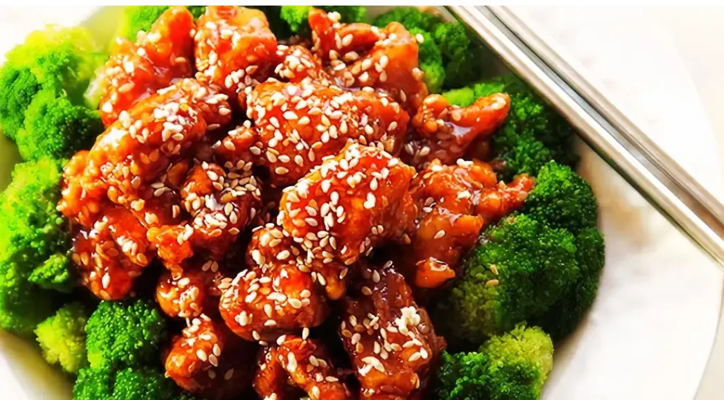 Sesame chicken served over steamed broccoli