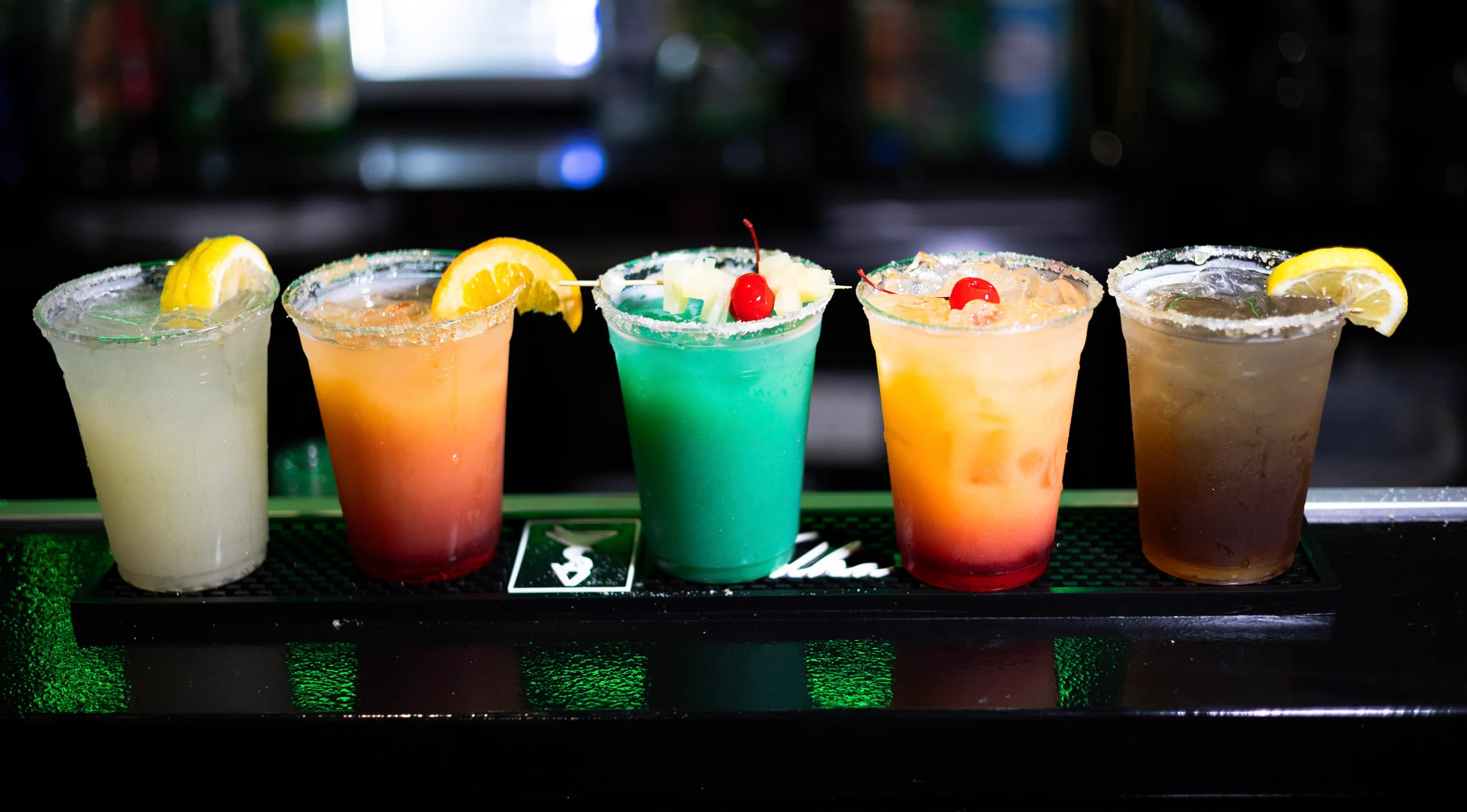 Colorful cocktails lined up at a bar