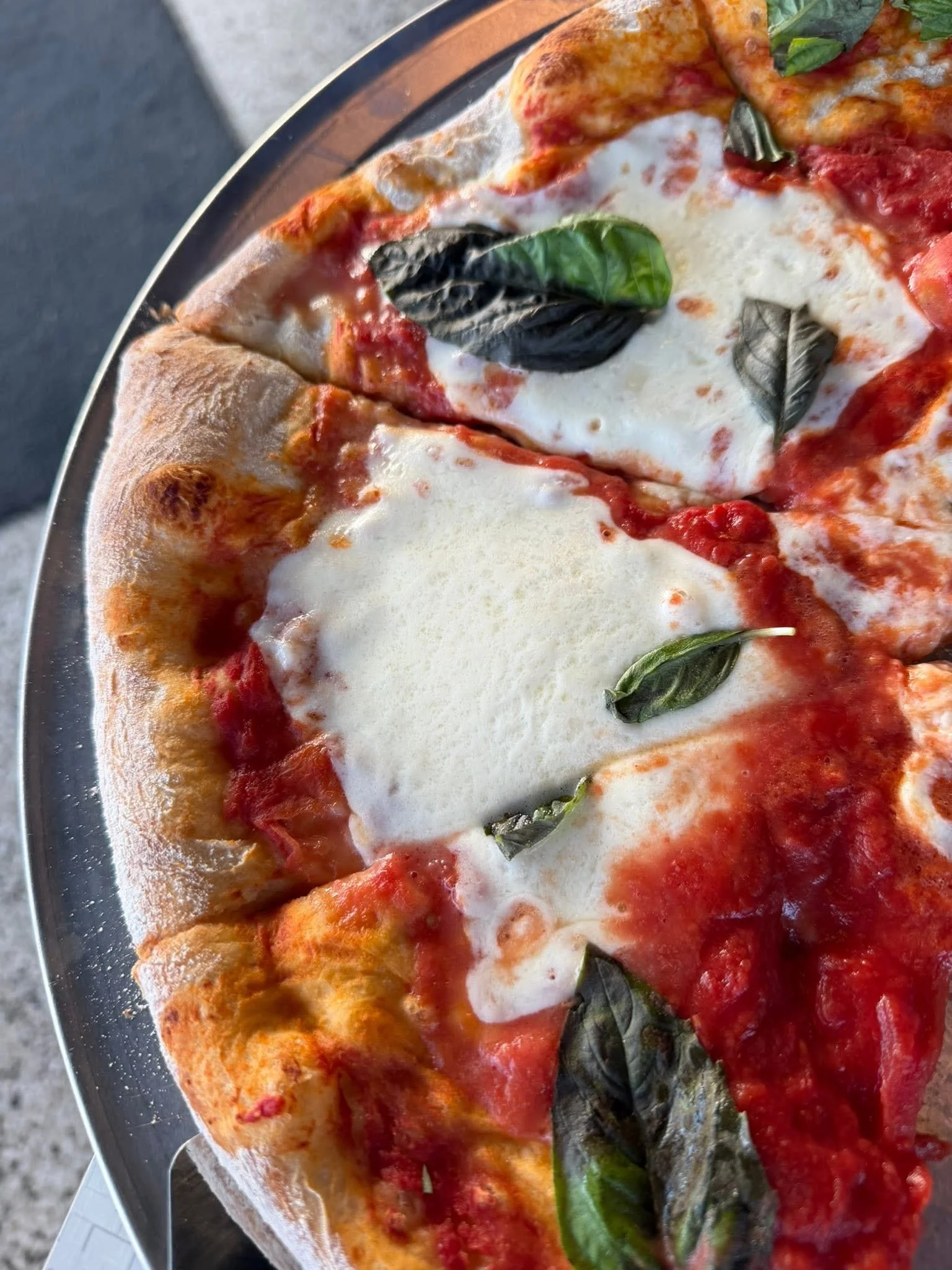 Margherita pizza topped with fresh basil and mozzarella