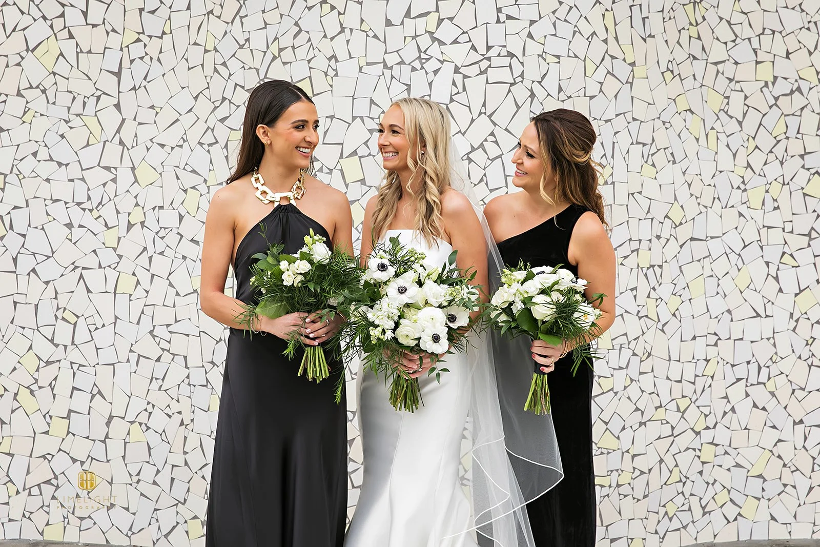 Bridesmaids in elegant dresses holding floral bouquets