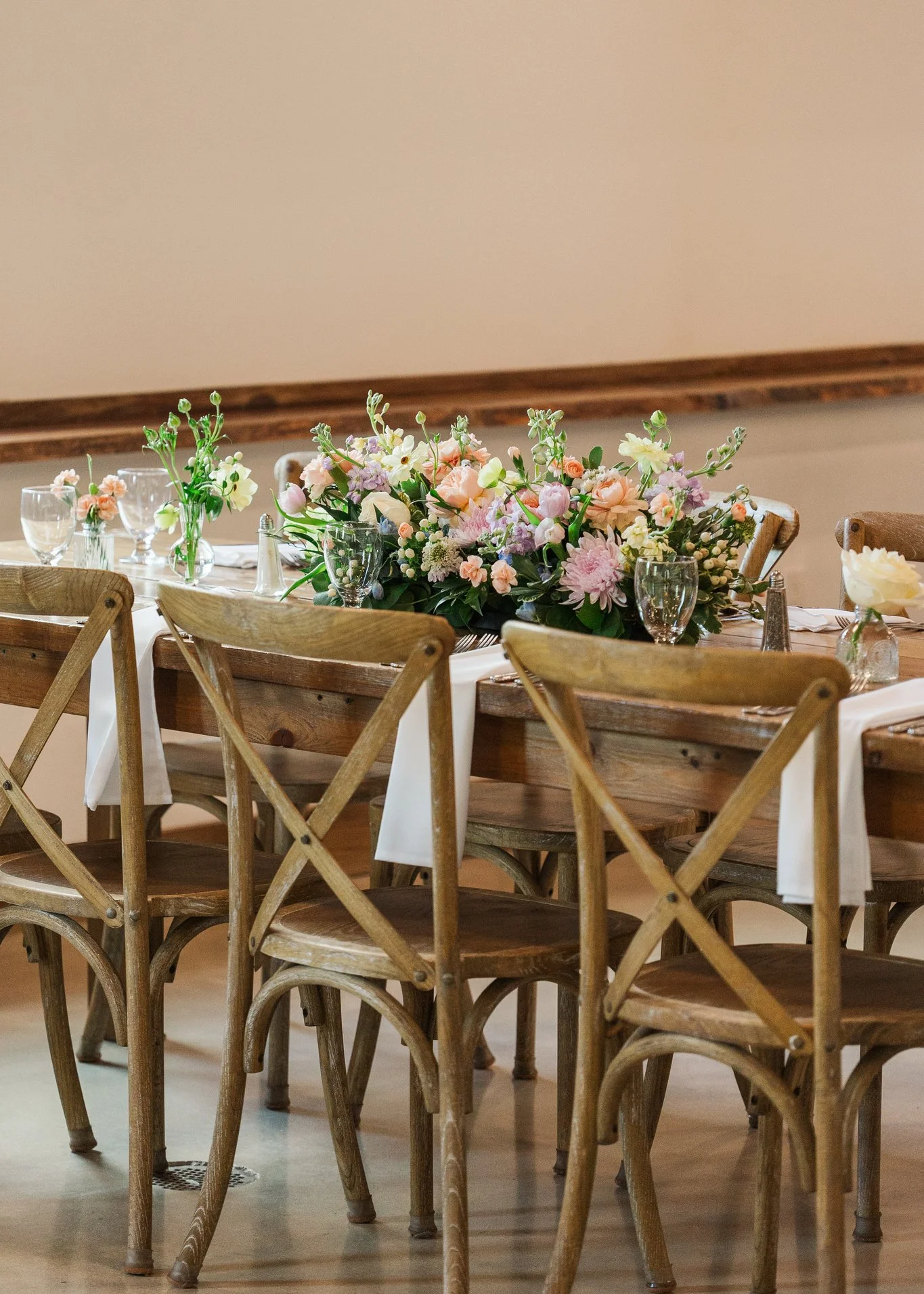 Elegant dining setup with floral centerpiece and wooden chairs