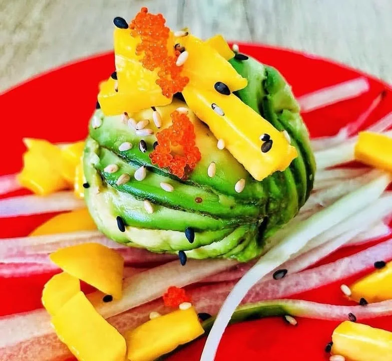 Japanese sushi roll with avocado, mango, and tobiko garnishes
