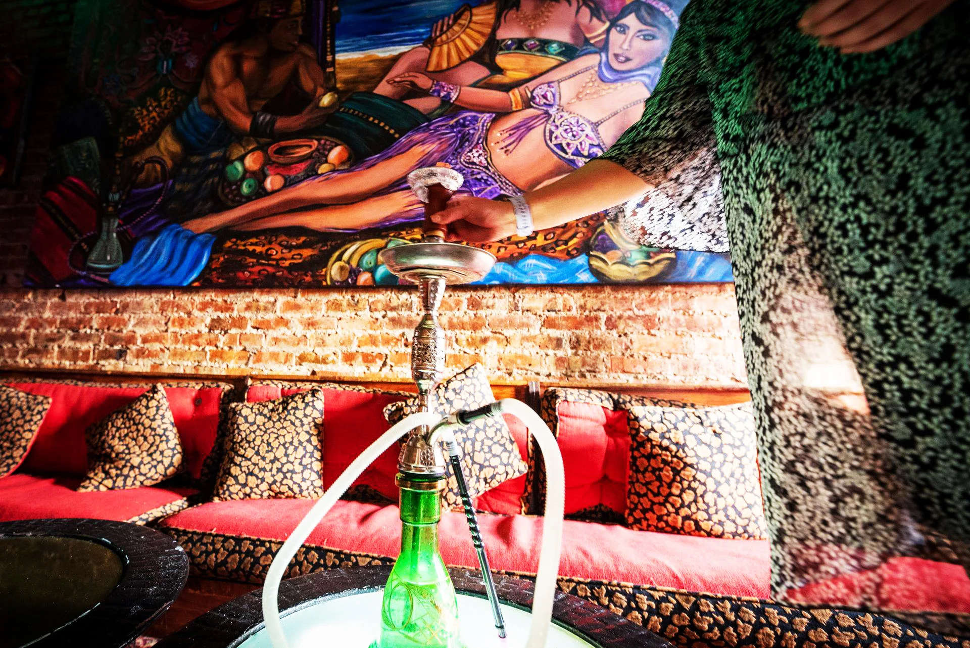 Cozy hookah lounge with vibrant mural and plush seating